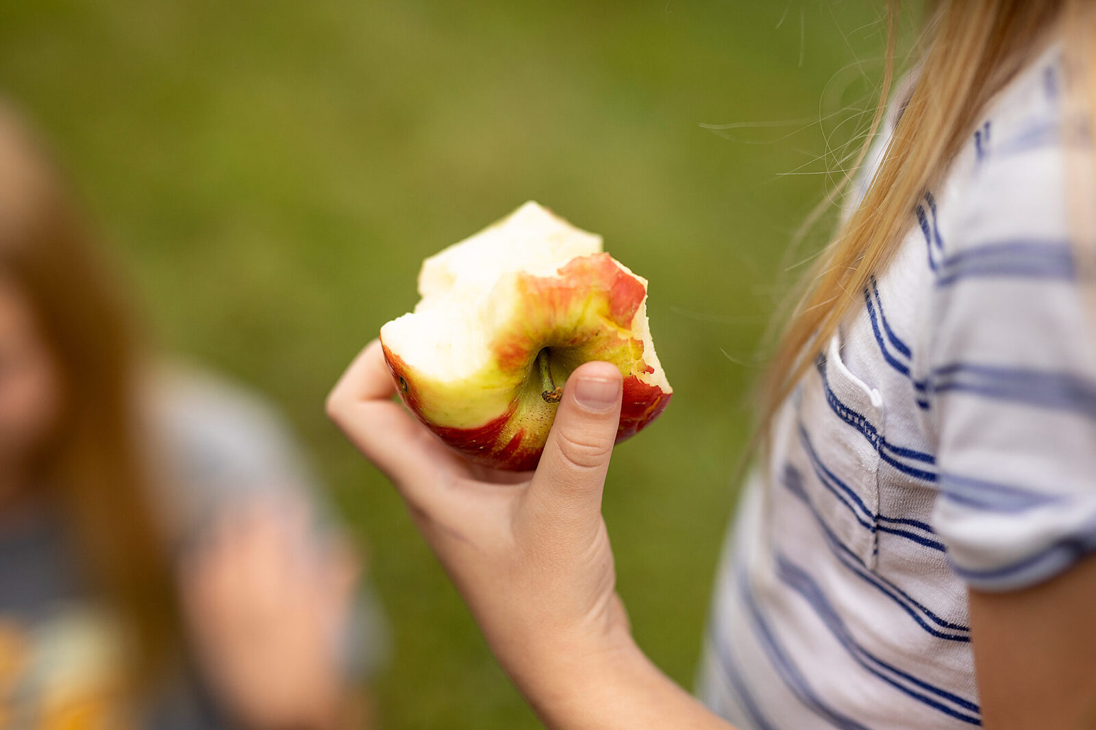 Girl holding half eaten apple