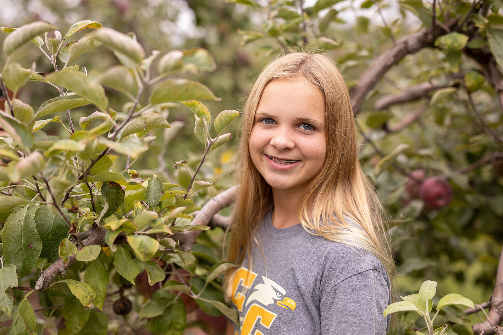 Young girl standing in front of an apple tree at apple hill orchard in mansfield ohio