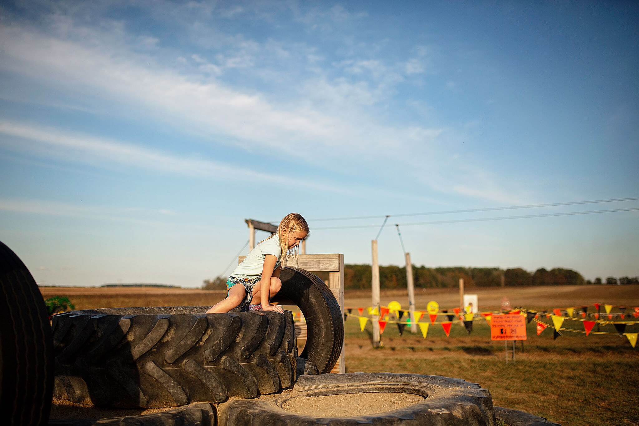 Girl jumping off a large tire at Lehners pumpkin patch