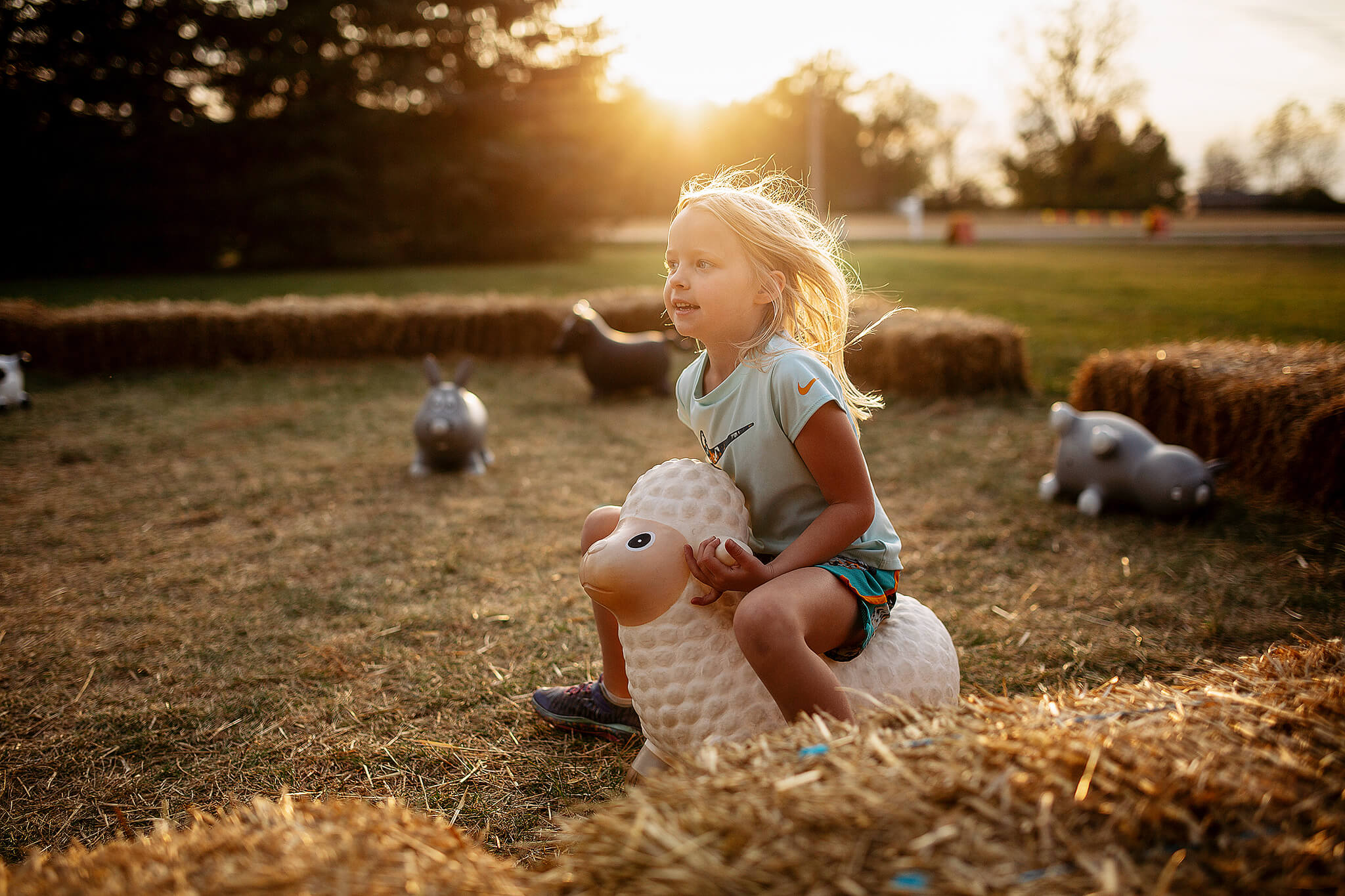 girl jumping on toe with sunshine behind at lehners pumpkin patch