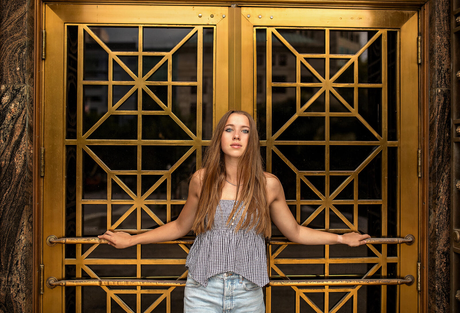 High school senior standing in front of golden doors in columbus, ohio