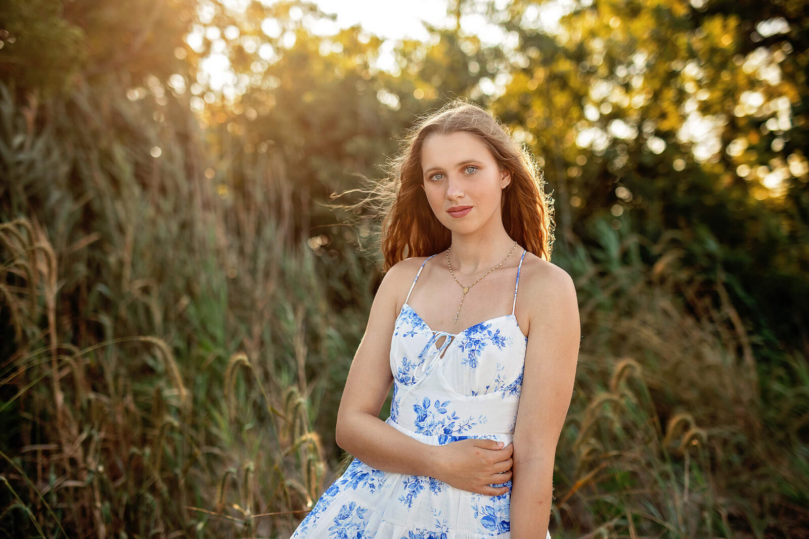 High school senior girl at East Harbor State park standing in front of beach grass