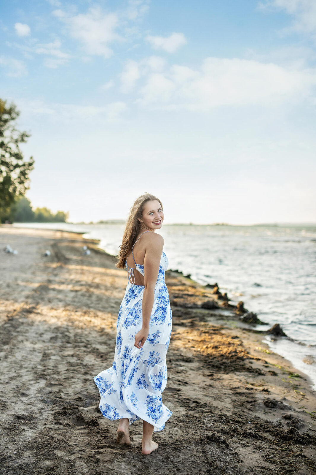 High school senior walking on East Harbor State Park looking behind her as she walks