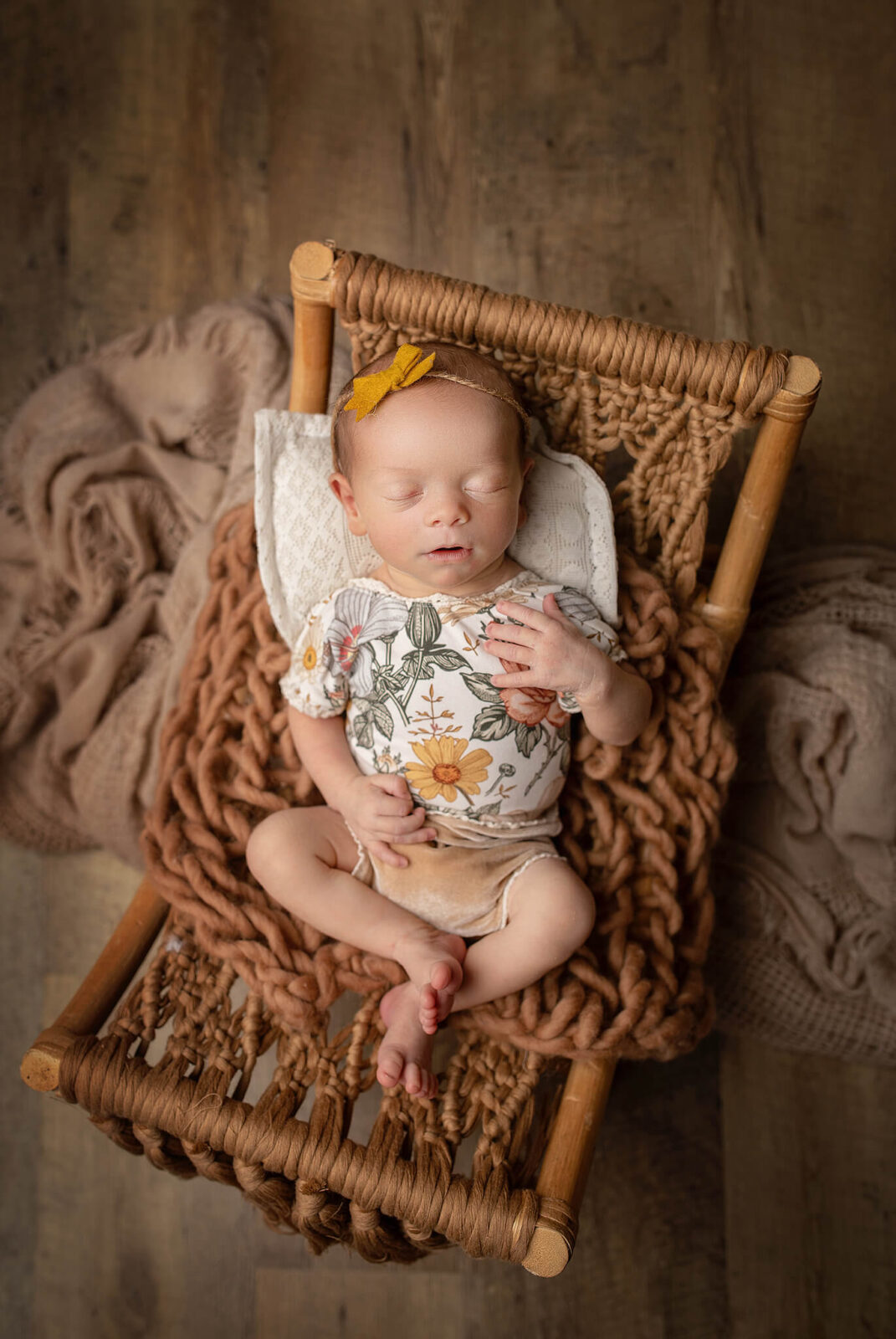 newborn laying on a macrame cot in a cute little outfit