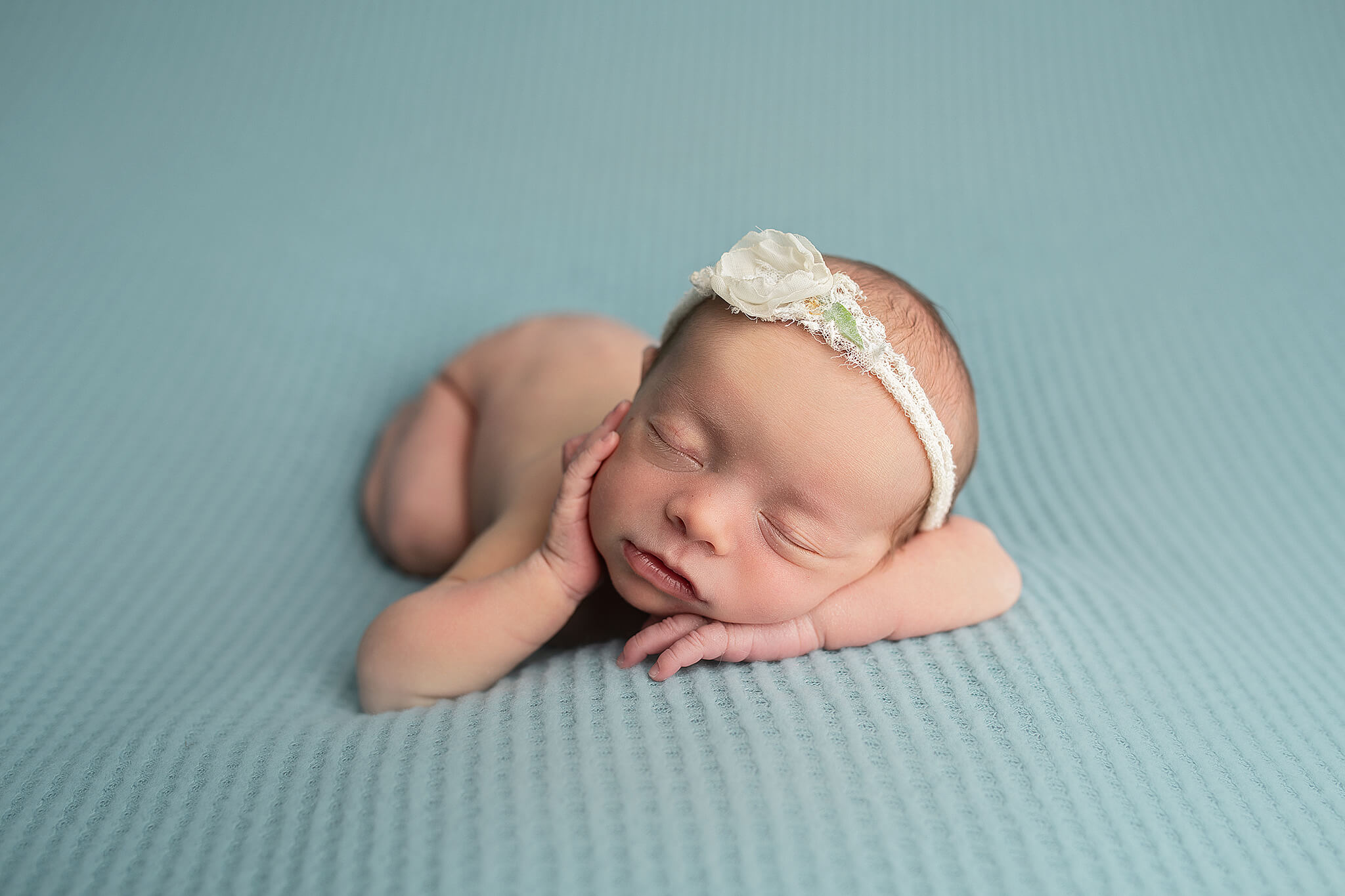 newborn baby girl on blue backdrop